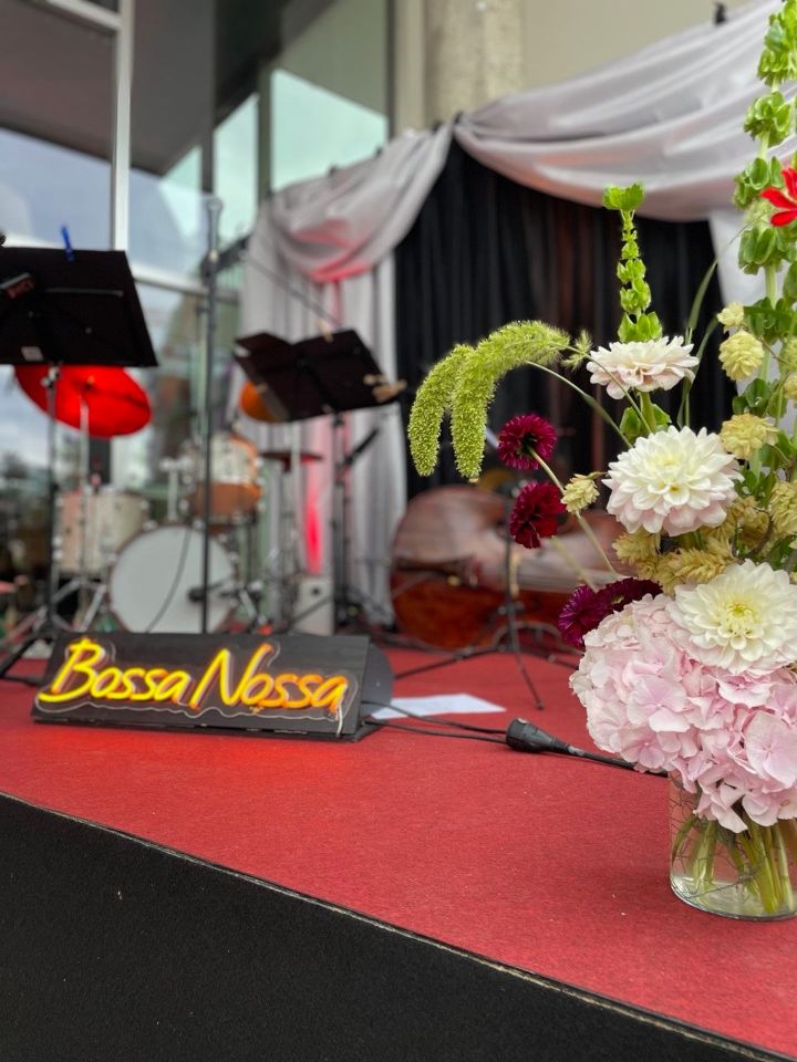 Bossa Nossa – Bühne mit Blumengesteck und Leuchtschild